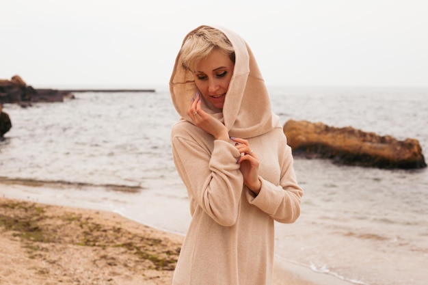 Hipster woman wearing dress near sea in autumn