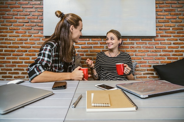 Hipster young couple freelancer using smart Laptop and mobile phone with smile action when working i