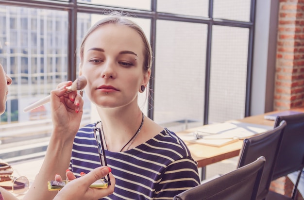 Hipster young freelancer make up in the Loft cafe workplace, Beauty and fashion concept