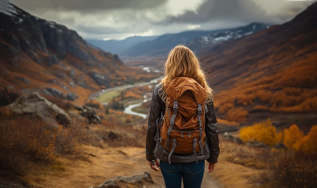 Hipster young girl with backpack enjoying sunset on peak of mountain Tourist traveler