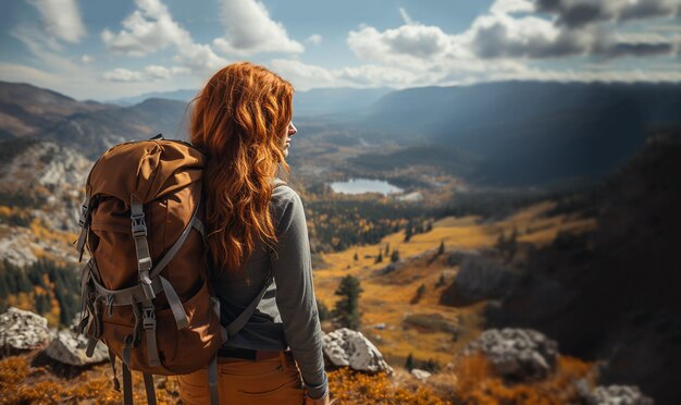 Hipster young girl with backpack enjoying sunset on peak of mountain Tourist traveler