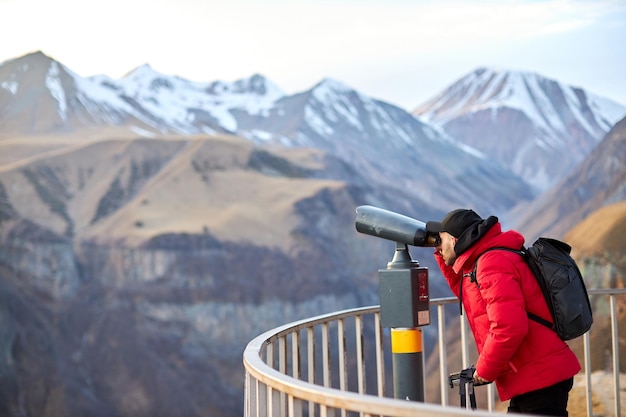 Hipster young man with black backpack looking on observation deck tourist traveler on background pan...