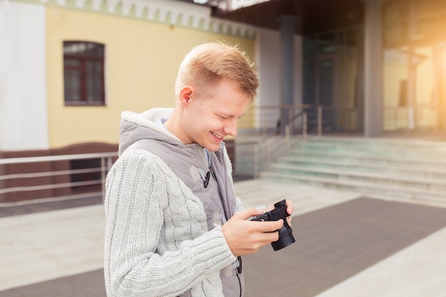 Hipster young man with a camera in the city, travel concept