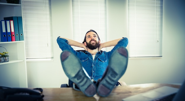 Foto hipster zakenman ontspannen aan zijn bureau