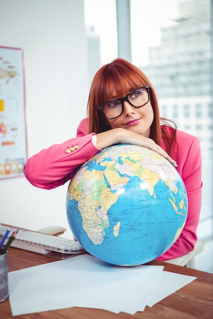 Hipster zakenvrouw leunen op een wereldbol