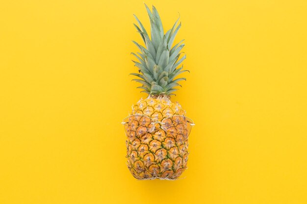 Hipsterananas met zonnebril tegen een gele achtergrond