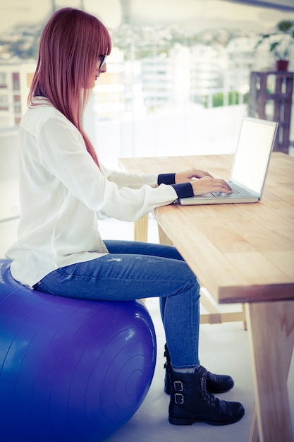 Foto hipsteronderneemster die haar laptop met behulp van