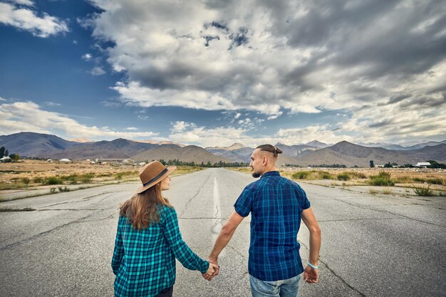 Hipsterpaar die op de weg lopen