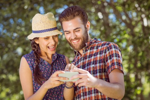 Hipsterpaar die telefoon bekijken