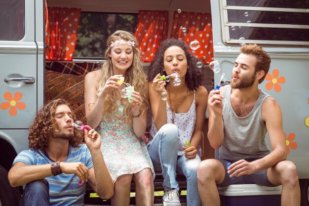 Hipsters blowing bubbles in camper van