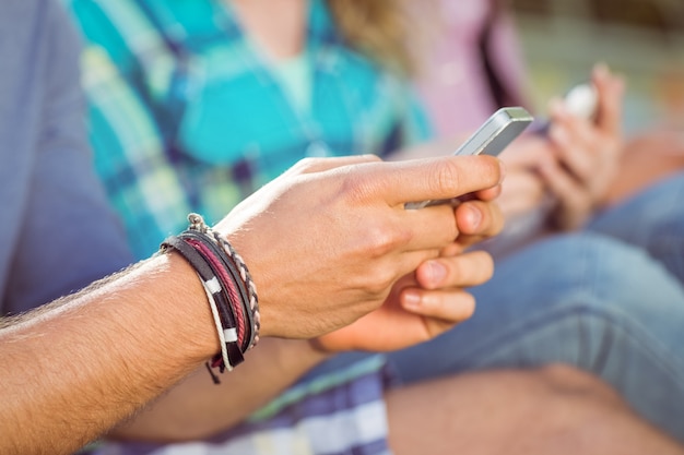 Hipsters sitting on the grass texting