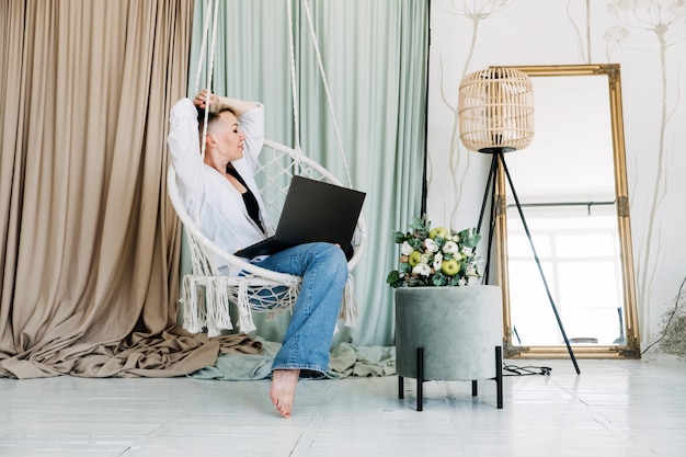 Hipstervrouwenblogger die met laptop in de schepper van het studiomoderne meisje met laptop werkt