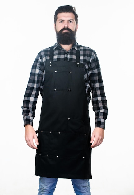 His beard works well Hipster with long beard and mustache in work apron Bearded hipster wearing barber or cooking apron Hipster man with bearded face and stylish hair Enjoying hipster lifestyle