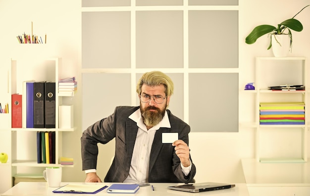 His business card bearded man sit at desk in office confident brutal businessman Elegant businessman analyzing data in smartphone Quarantine agile business lawyer use laptop for work copy space