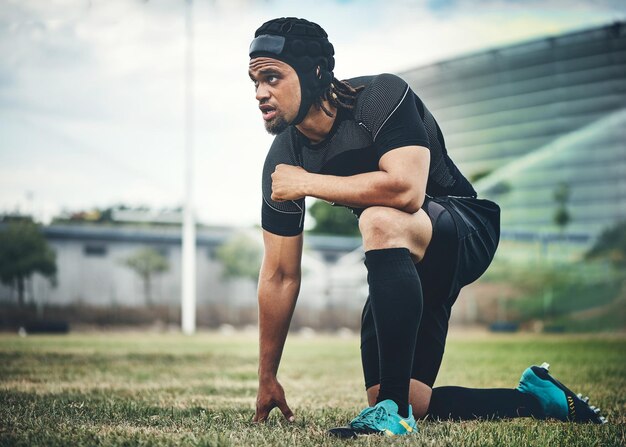 His eyes are on the prize Full length shot of a handsome young rugby player kneeling down on the field during the day