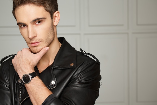 His eyes stop the time. Studio portrait of a stunning handsome rocker man touching his chin looking thoughtfully