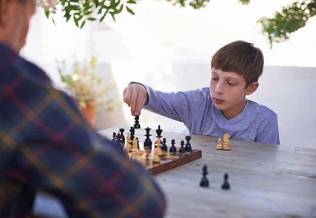 His granddad is a worthy adversary Shot of a young boy playing chess with his grandfather