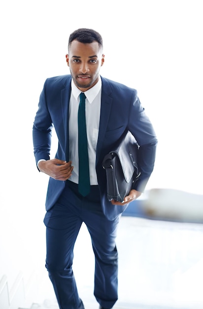 On his way to a meeting A handsome african american businessman walking up the stairs while carrying a bag