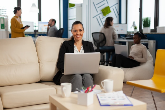 Hispanic business woman smiling at camera holding laptop