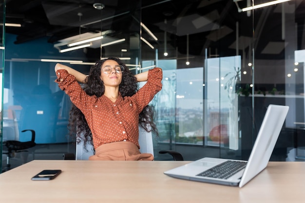 Hispanic business woman with closed eyes dreaming at workplace closeup female worker with hands