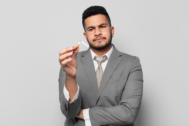 Hispanic businessman angry expression. quitting smoking concept