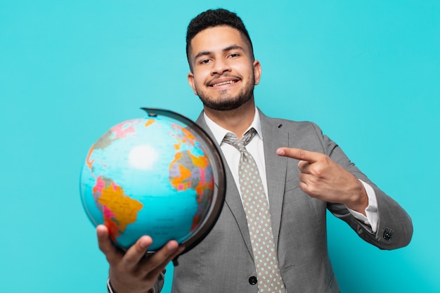 Hispanic businessman pointing or showing and holding a world planet model