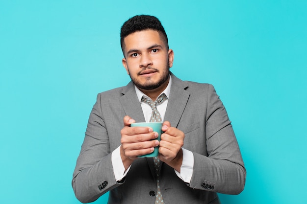 Hispanic businessman scared expression and holding a coffee mug