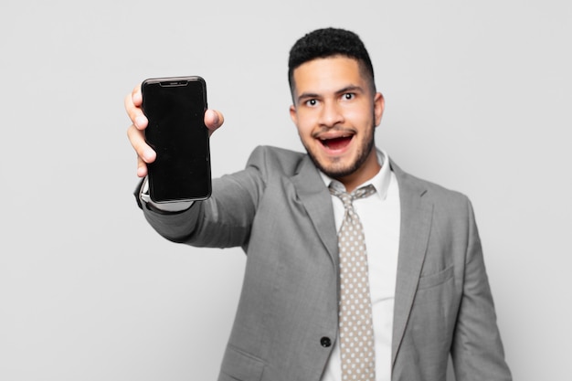 Hispanic businessman surprised expression and holding a phone