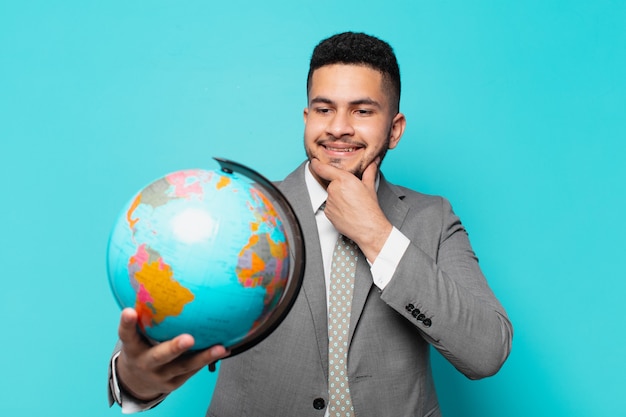 hispanic businessman thinking expression and holding a world planet model