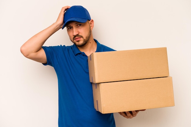 Hispanic delivery man isolated on white background being shocked she has remembered important meeting