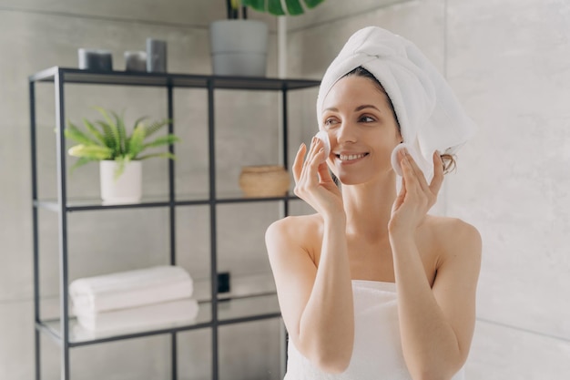 hispanic girl cleanse skin by cotton pads after shower in bathroom skincare routine natural beauty