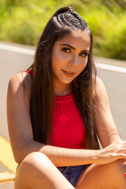 Hispanic girl in the middle of highway, nature in the background.