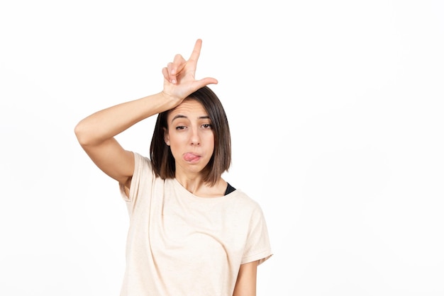 Hispanic girl with mad face making L sign representing a looser.