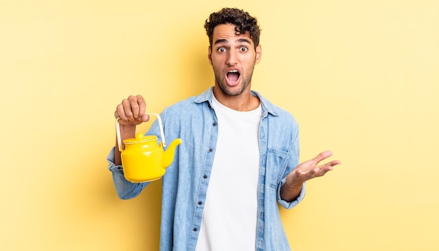 Hispanic handsome man feeling extremely shocked and surprised. teapot concept