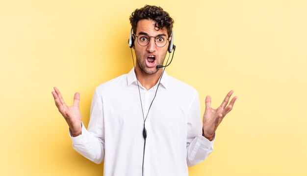 Hispanic handsome man feeling extremely shocked and surprised. telemarketer concept