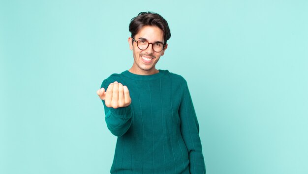 Hispanic handsome man feeling happy, successful and confident, facing a challenge and saying bring it on! or welcoming you