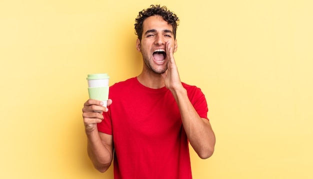 Hispanic handsome man feeling happygiving a big shout out with hands next to mouth take away coffee concept