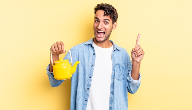 Hispanic handsome man feeling like a happy and excited genius after realizing an idea. teapot concept