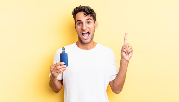 hispanic handsome man feeling like a happy and excited genius after realizing an idea. vaporizer concept