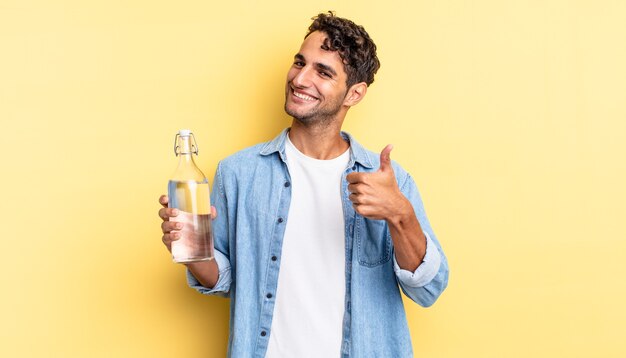 Hispanic handsome man feeling proud,smiling positively with thumbs up. water bottle concept