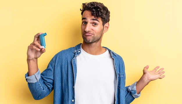 Hispanic handsome man feeling puzzled and confused and doubting asthma concept