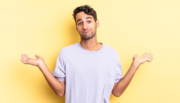 Hispanic handsome man feeling puzzled and confused and doubting