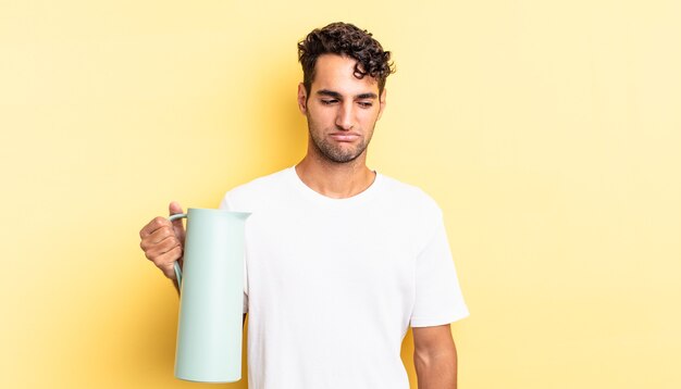 Hispanic handsome man feeling sad, upset or angry and looking to the side. coffee thermos concept