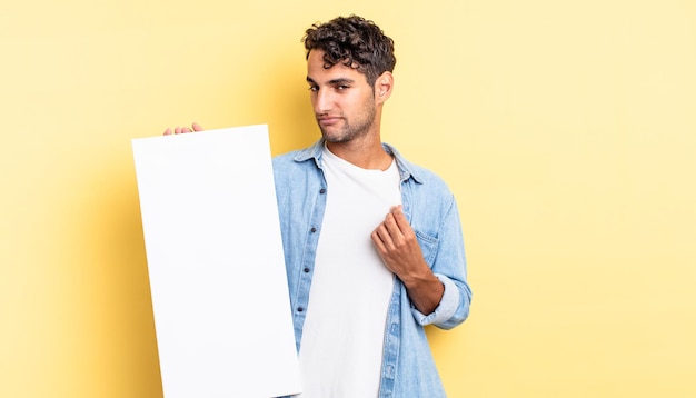 Hispanic handsome man looking arrogant, successful, positive and proud. empty canvas concept