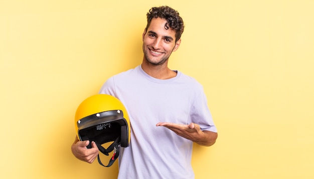 Hispanic handsome man smiling cheerfully, feeling happy and showing a concept. motorbike helmet concept