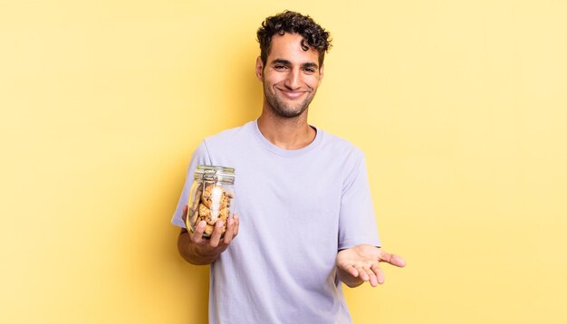 Hispanic handsome man smiling happily with friendly and  offering and showing a concept. cookies concept