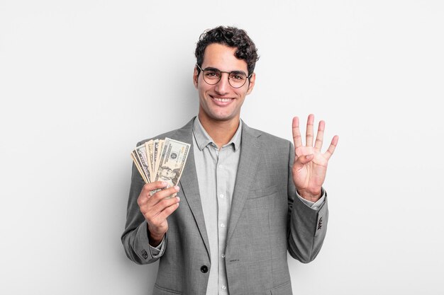 Латиноамериканский красивый мужчина улыбается и выглядит дружелюбно, показывая номер четыре. концепция деловых и долларовых банкнот