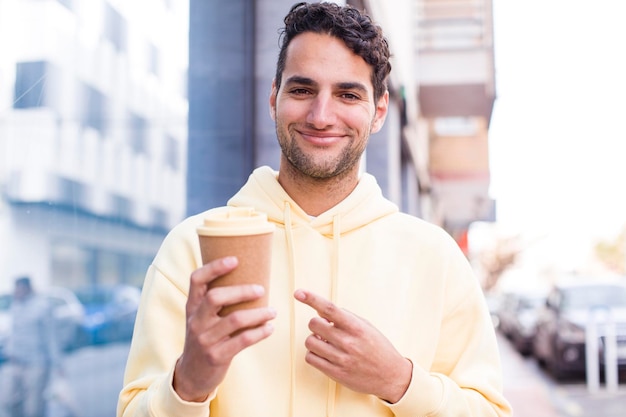 ホット テイク アウェイ コーヒー ドリンク アウトドア コンセプトを持つヒスパニック系のハンサムな男