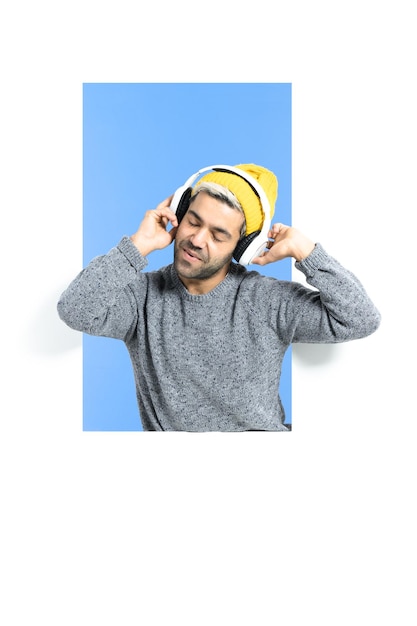 Hispanic hipster listening to music on headphones and dancing