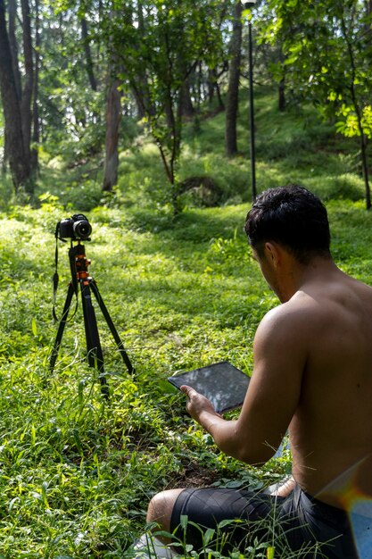 Hispanic latino man giving class while being recorded by a\
camera holding tablet in his hand mexico